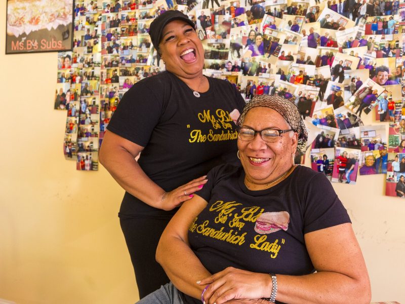 Stacy Bizzard (L) and her mother, Bonnie Harris, are co-owners of Ms. B's Sub Shop. They pose here in front of a wall of photos of satisfied customers. (Ziggy Mack)