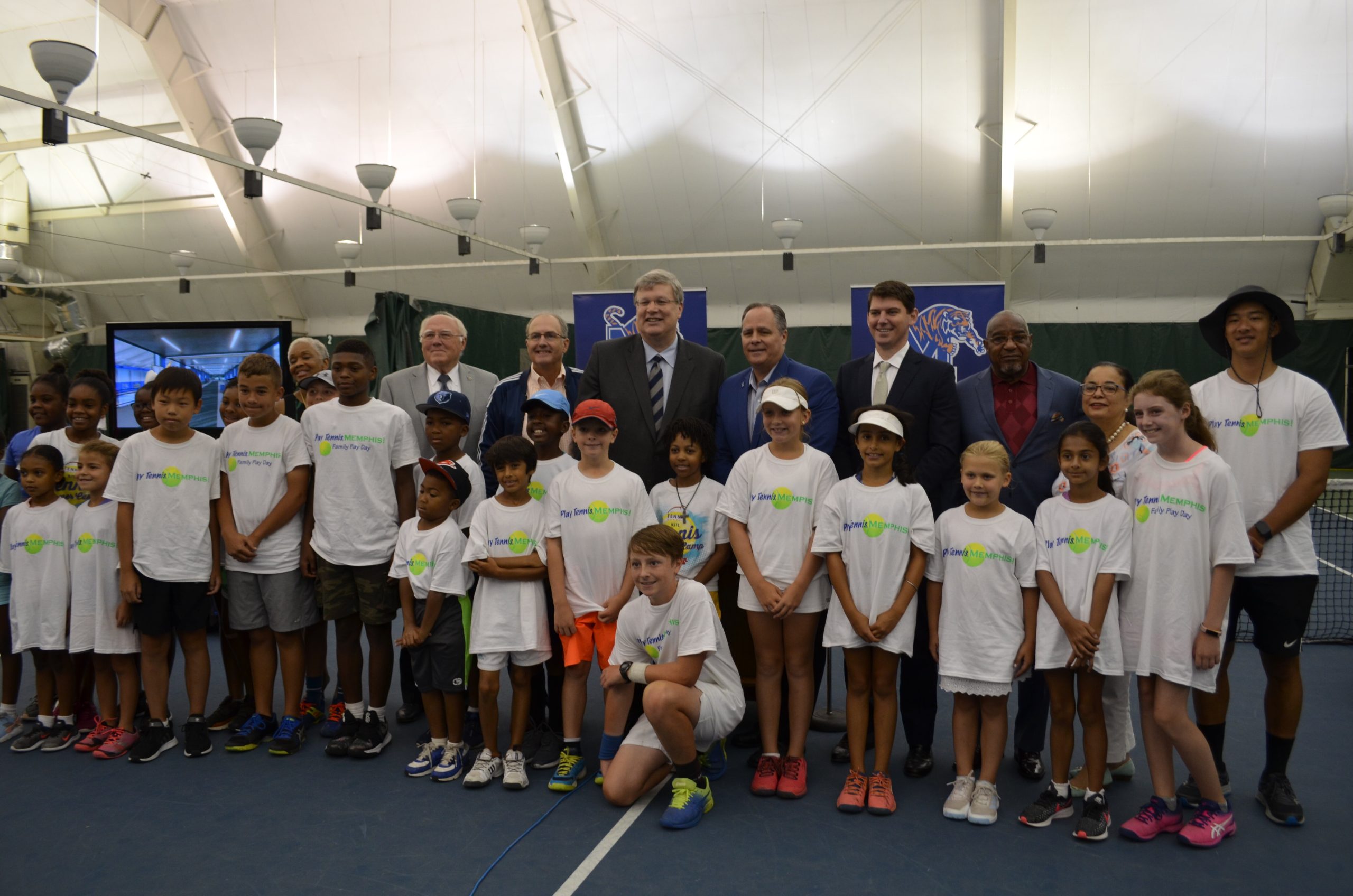 Leftwich tennis center renovation announcement press conference on Aug. 5, 2019. Back row from L to R: Former interim U of M athletic director Allie Prescott, Tennis Memphis Executive Director Stephen Lang, Memphis Mayor Jim Strickland, U of M President M. David Rudd, Memphis City Councilman Worth Morgan, Tennis Memphis Board Chair Bob Mebane. Front row: The junior players and future stars of Tennis Memphis. (Tennis Memphis)
