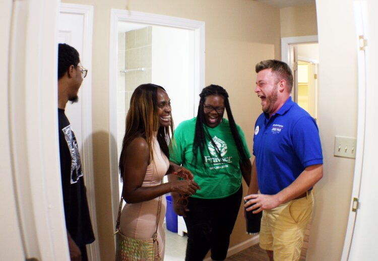 Guests share a laugh at the Frayser CDC open house. The homes they toured are three-bedroom, two-bath and will be listed at $88,000. (Cole Bradley)
