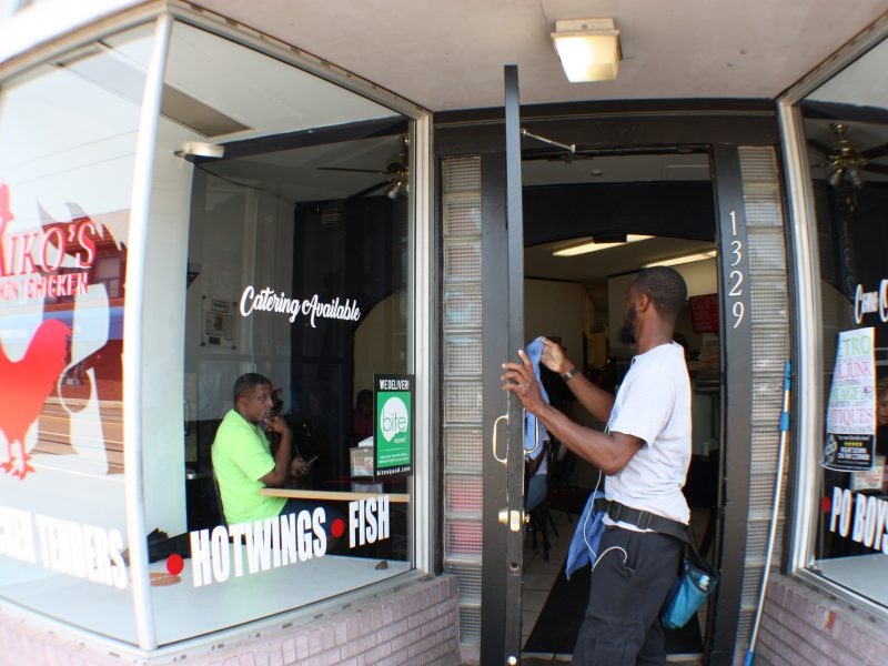 Walter Clark, owner of Outstanding Touch window services, puts the finishing touches on the door of Riko's Kickin Chicken, located at 1329 Madison Avenue. (Cole Bradley)