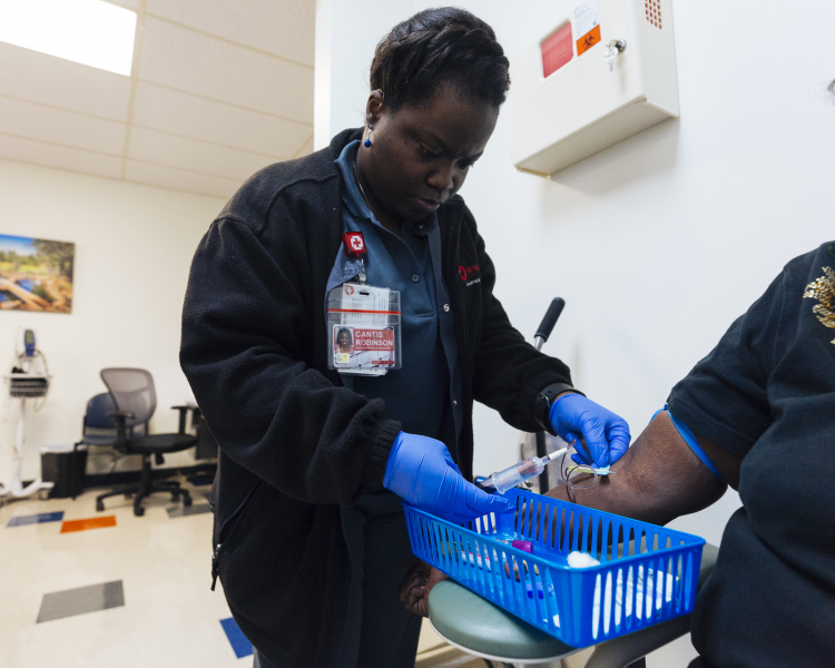 Cantice Robinson takes blood samples from a patient at a new clinic that opened in February 2019 to serve the healthcare needs of Memphis' homeless population. (Ziggy Mack)