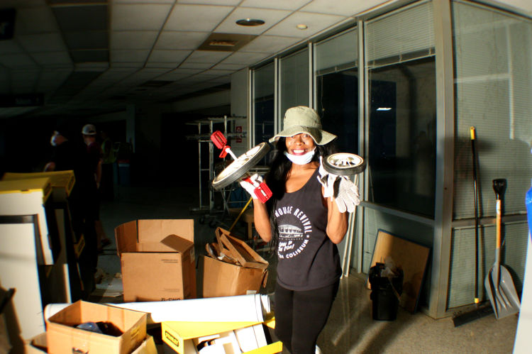 Coliseum Coalition board member Carolyn Chatman holds up pieces of a dismantle tricycle found in an abandoned office on cleanup day. (Shelda Edwards) 