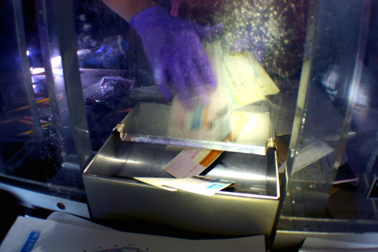 Volunteers armed with flashlights clean debris, trash and relics from the past from the venue's old will call office. They found unused tickets from RiverKings hockey games, a Jay-Z concert and a Barney and Baby Bop show. (Shelda Edwards) 