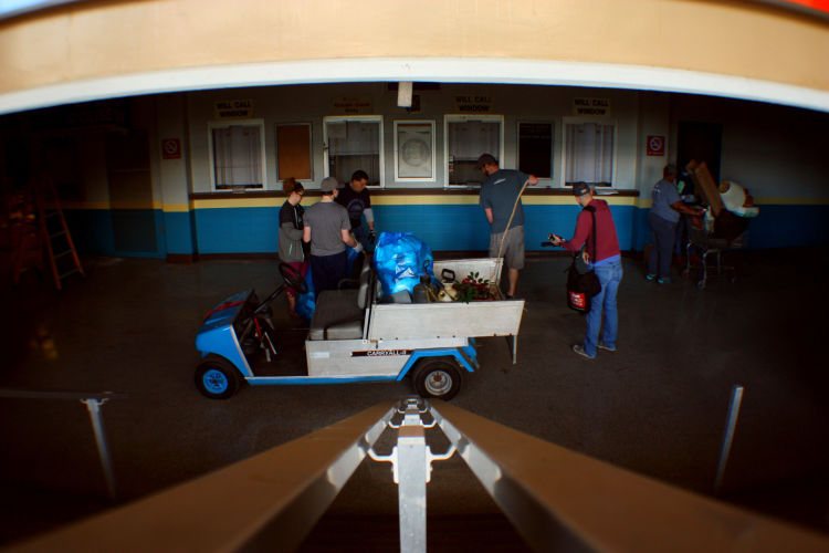 Volunteers use a golf cart to transport trash and debris from the lower level corridor that rings the arena floor. A rendering of the Coliseum's seat chart is still displayed in a frame at the center of the photograph. (Shelda Edwards)  