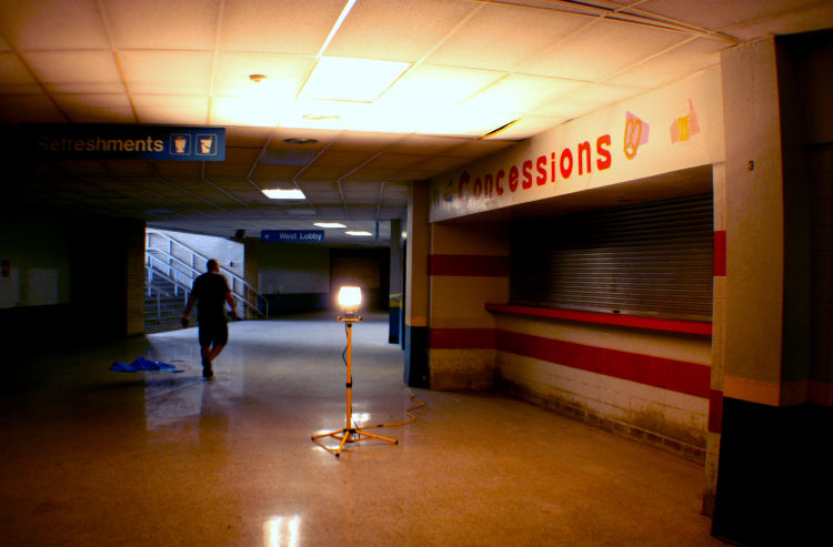 Chooch Pickard, the Coliseum Coalition's vice president, walks the lower-level corridor near a shuttered concession stand. (Shelda Edwards) 
