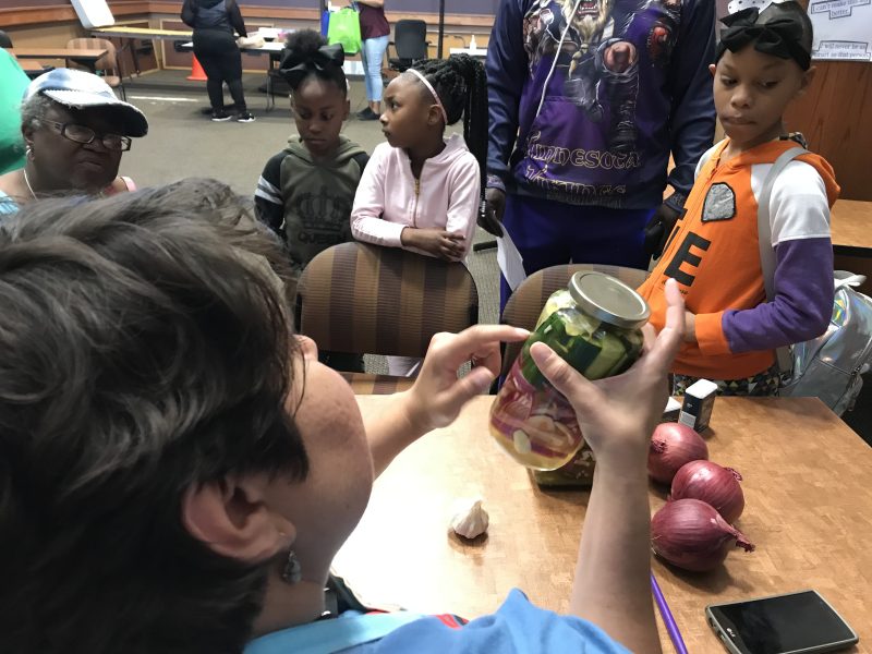 Melissa Sierra, Connect Crew manager for the Memphis Public Library system, talks about the process of making brine for a pickling class at the How-To-Festival, held at the Whitehaven Library on Saturday, April 27. (Kim Coleman)