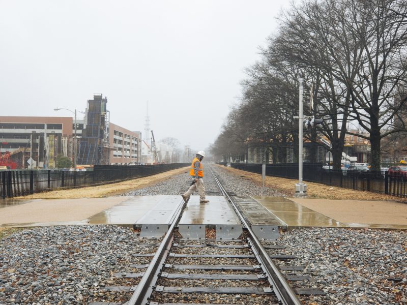 A construction worker walks across the Southern Avenue tracks near the University of Memphis campus at the heart of the University District. (Ziggy Mack)