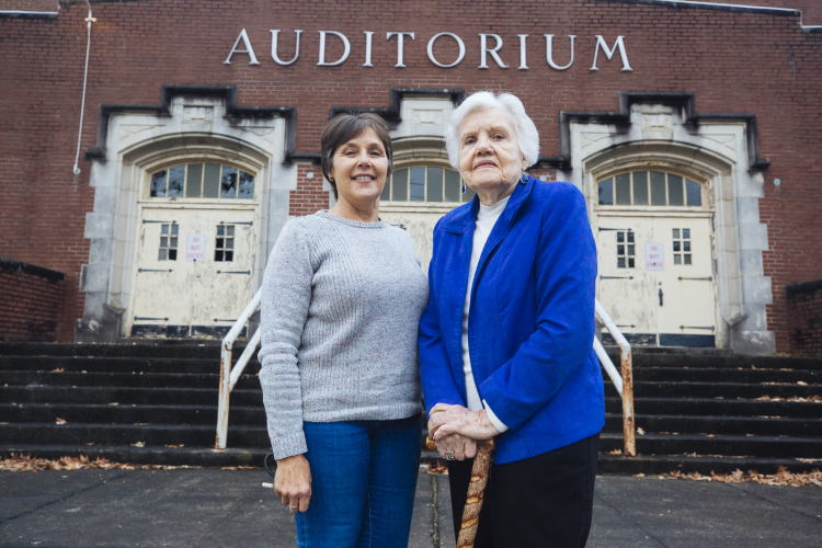 Former Messick Buntyn resident Dorene Holman (R) stands in front of the old Messick School auditorium with her niece Leah Flagg-Wiggins. Holman's four children graduated from Messick and Flagg-Wiggins was president of the 'Twelve Year Club', students that attended Messick for 12 years. (Ziggy Mack)