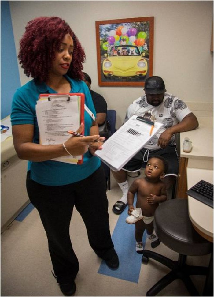 An outreach coordinator at the UT Le Bonheur Pediatric Specialists clinic performs a needs assessment with a family at their child's checkup. (Submitted) 