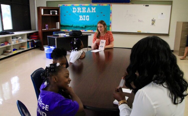 Two of Agape's staff members work with students on reading at Whitney Achievement Elementary School. The staff members, though employed by the Memphis nonprofit, are integrated into school life. (Caroline Bauman/Chalkbeat Tennessee)