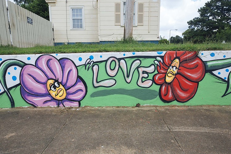 A mural decorates a retaining wall behind Treadwell Middle School. The modest home in the background is an example of the post-World War II houses found throughout the area. (Ziggy Mack)