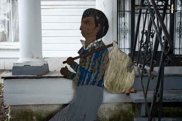 A wooden cutout of an escaping slave leans against the front porch of Slave Haven museum. (Brandon Dahlberg)