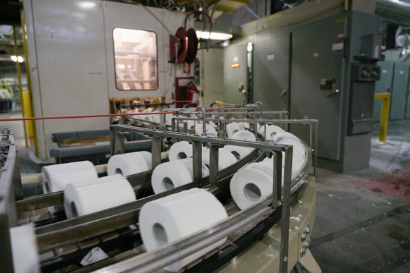 Rolls of toliet paper, freshly cut from logs travel down a conveyor system. (Brandon Dahlberg)