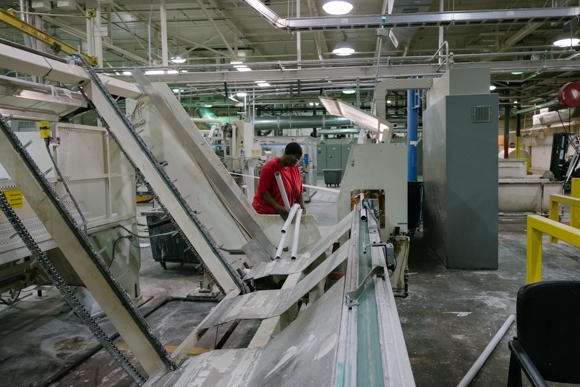 A woman prepares cardboard tubes that parent rolls will be transfered onto to form logs. (Brandon Dahlberg)