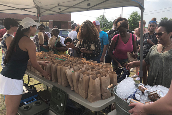 Members of the MMDC team hand out sack lunches for the June 2nd Treedom Memphis community picnic. (Cole Bradley)