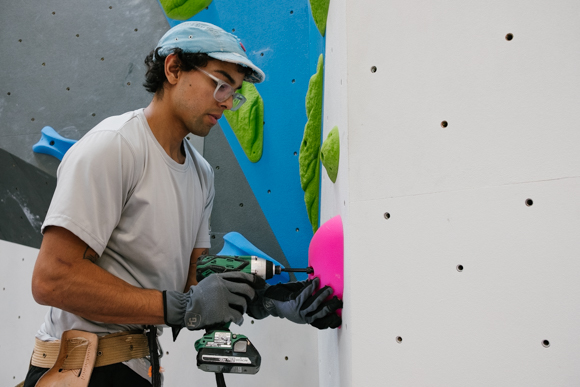 Josh Jimenez, on staff at Memphis Rox, works to set a new climbing route on one of the bouldering walls. (Brandon Dahlberg)