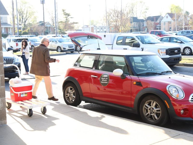 Volunteers load up their cars at MIFA headquarters as they prepare for another day’s delivery of Meals on Wheels.