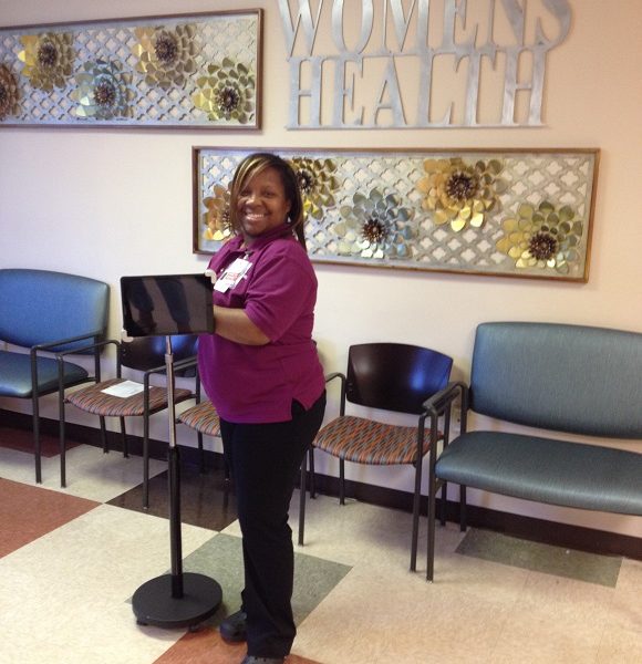 Venetia Bennett displays one of the kiosks used to gather patient feedback at the Women's Health Center of Christ Community Health Services.
