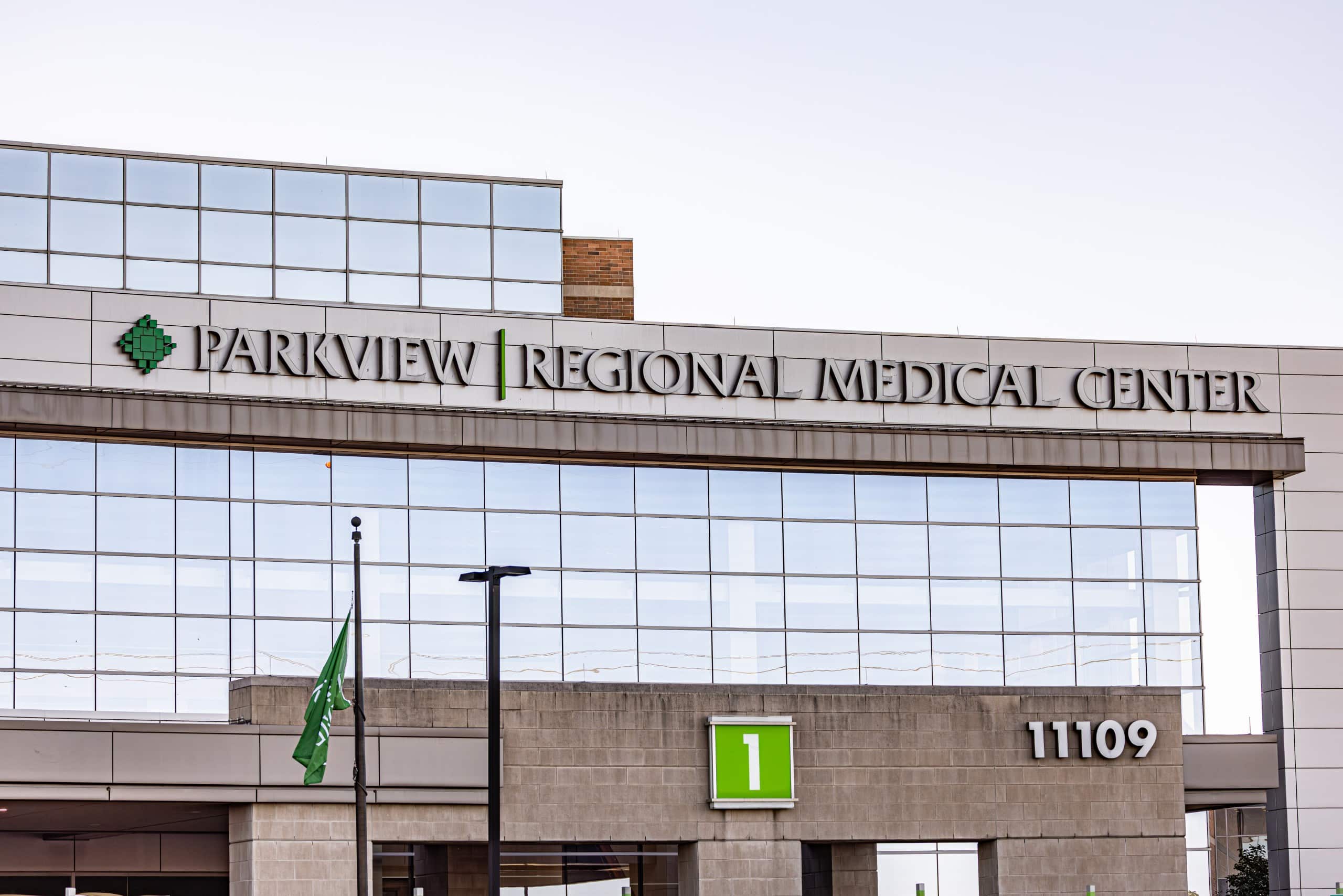A large grey and brown hospital with big windows and a sign in white lettering that reads, "Parkview Regional Medical Center".