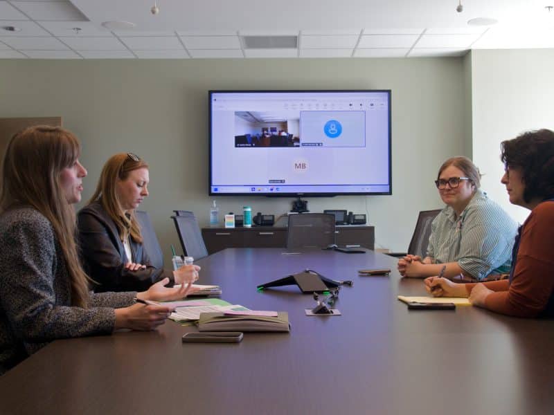 Chelsie Wilkinson, Megan Murphy, Nicky Bates, and Lisa Long meet to discuss Room at the Inn's recuperative care project.